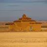 Palomar de adobe en un campo de cereal segado bajo un cielo amplio, cerca de Tapioles