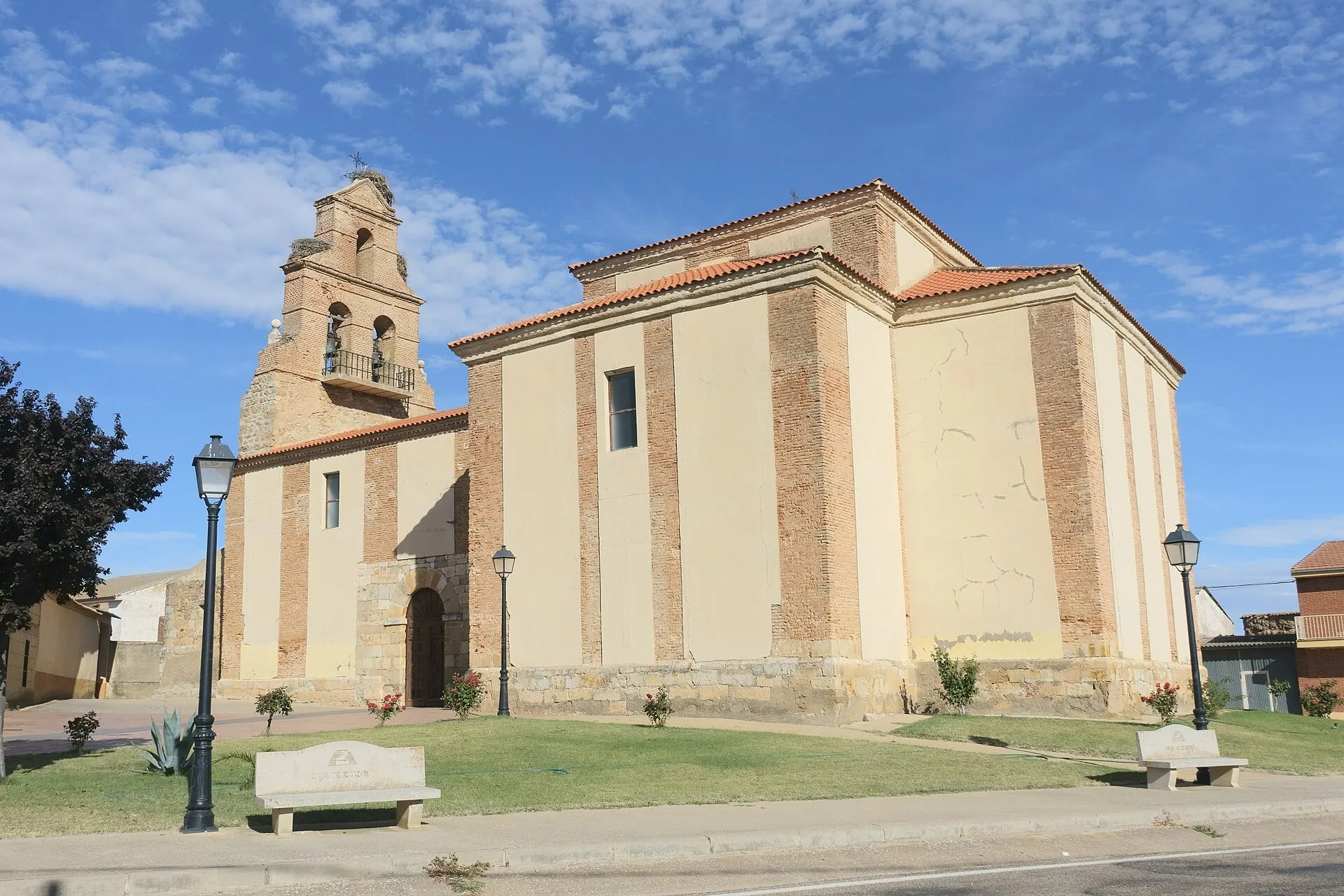 Iglesia de San Pelayo de Cañizo, de ladrillo y tapia encalada, con espadaña y nidos de cigüeña