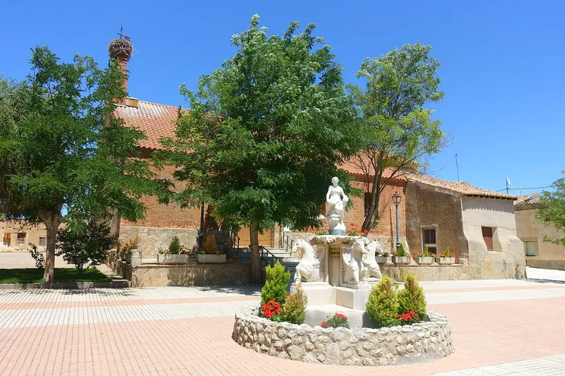 Plaza de Cotanes del Monte con una fuente de caballos y la iglesia de San Pedro detrás