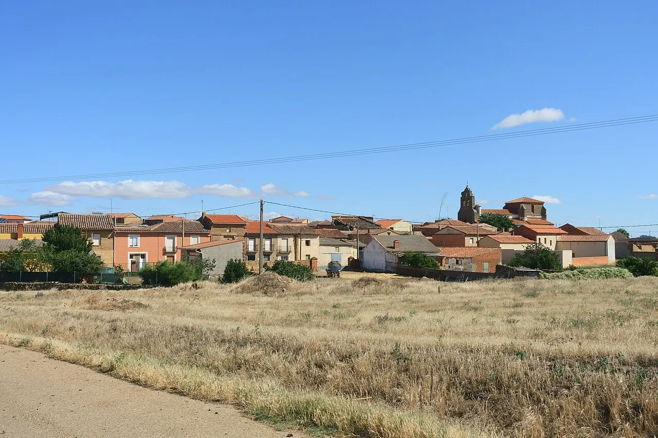 Vista general de Prado, con sus casas y la torre de la iglesia tras un campo de hierba seca