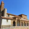 Iglesia de San Babilés de Quintanilla del Olmo con torre de ladrillo y pórtico de arcos