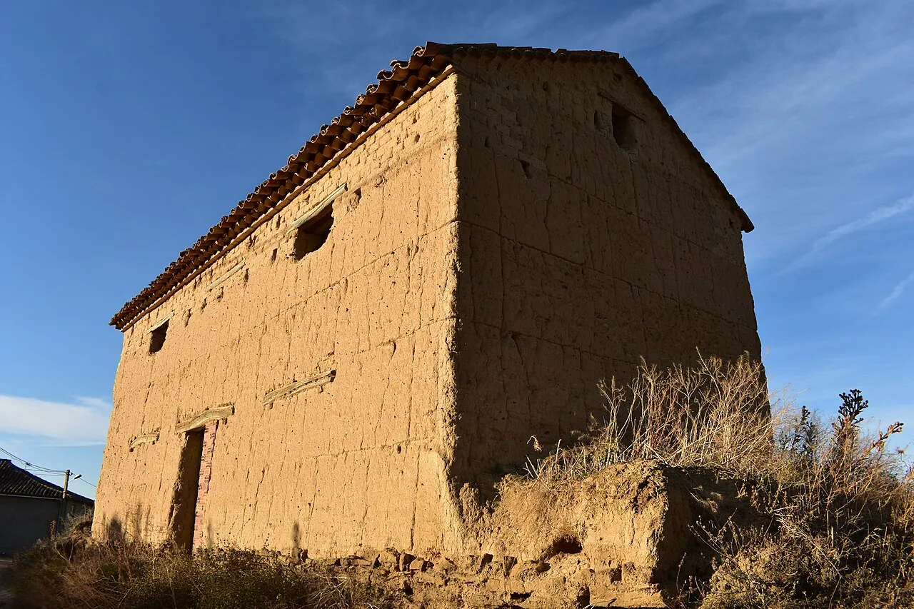 Construcción tradicional de adobe con tejado de teja en Vidayanes, bajo un cielo azul