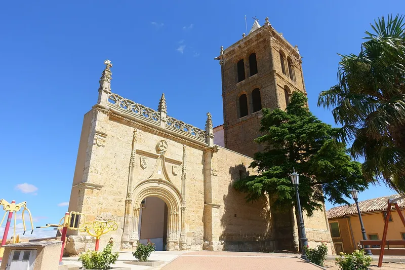 Portada gótica de piedra y torre de la iglesia de San Vicente en Villar de Fallaves