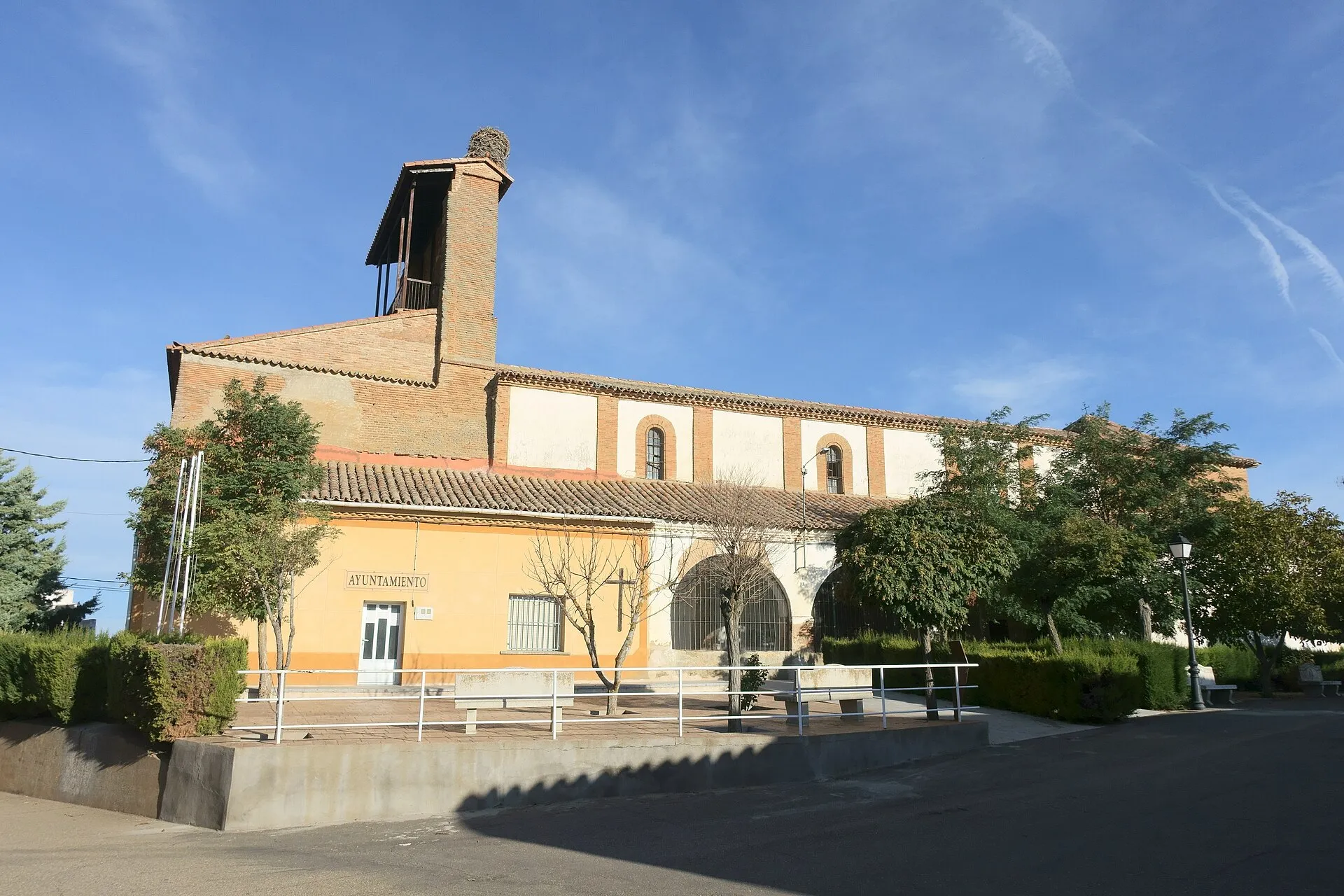 Iglesia de Nuestra Señora del Realengo y Ayuntamiento de Villárdiga junto a una plaza con árboles