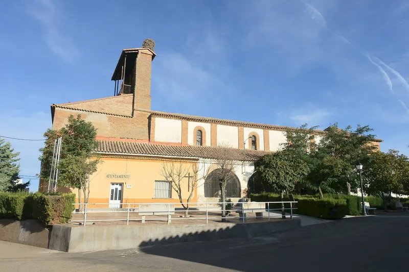 Iglesia de Nuestra Señora del Realengo y Ayuntamiento de Villárdiga junto a una plaza con árboles